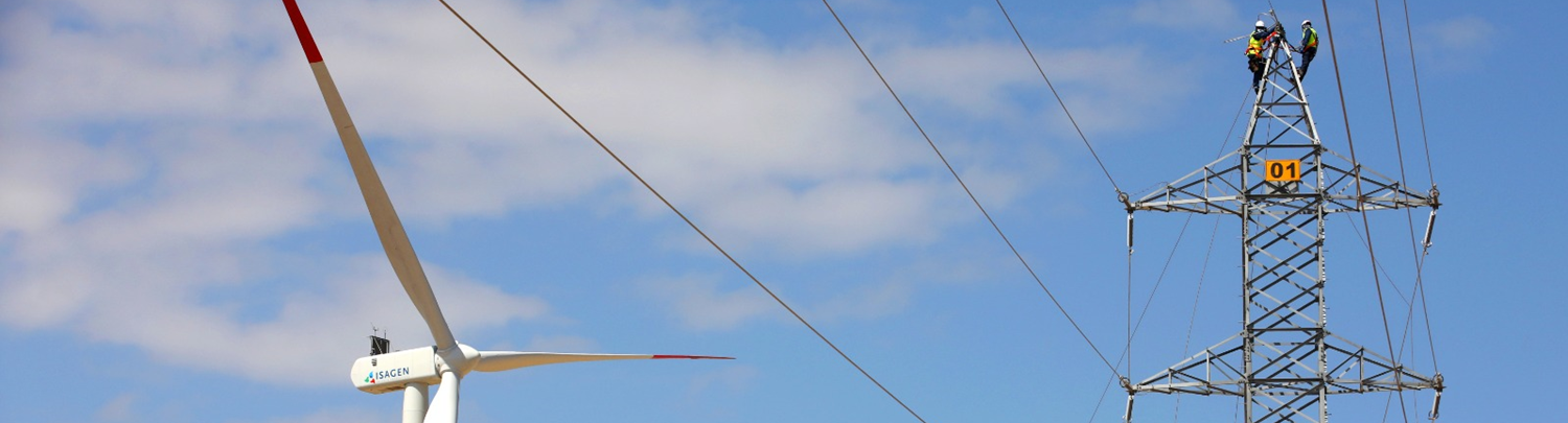 al fondo cielo azul despejado y a la derecha una torre de transmisión a lado de un torreo eólica de energía